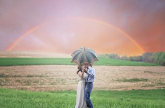 a couple kissing behind the umbrella